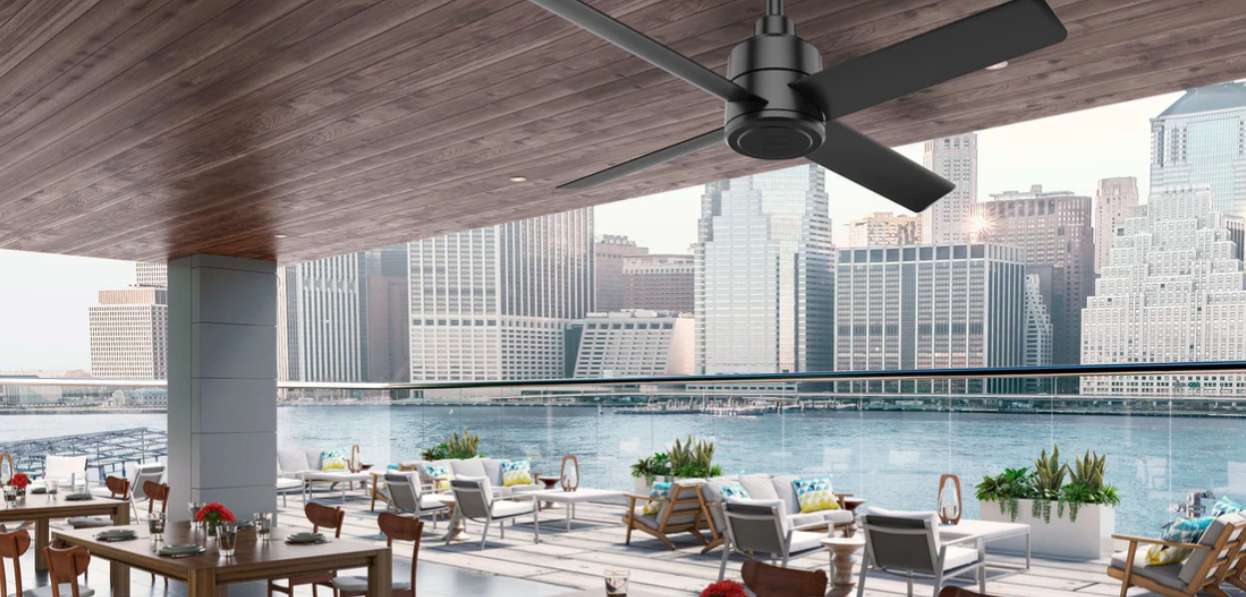 A stylish black ceiling fan on a city deck overlooking the water.