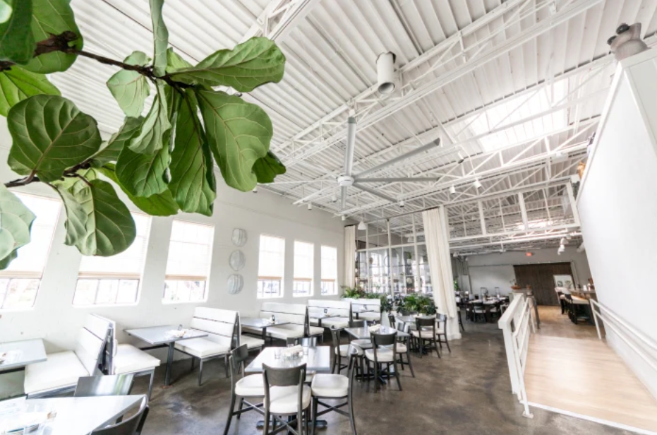 An image of the inside of a restaurant with large, white fans mounted to the ceiling.