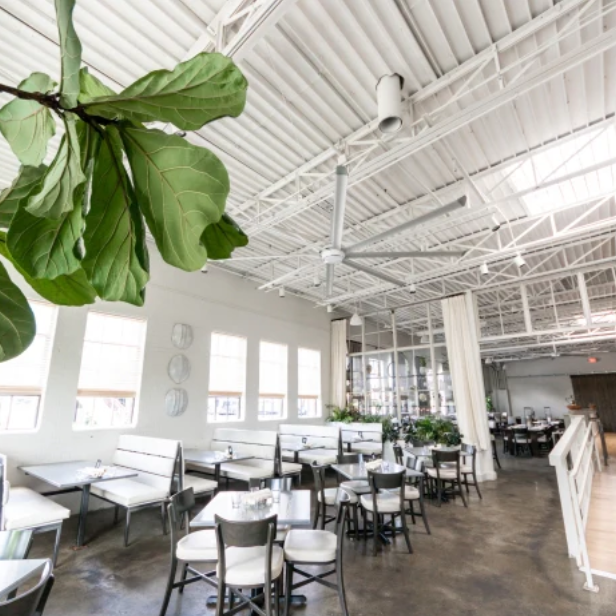An image of the inside of a restaurant with large, white fans mounted to the ceiling. 